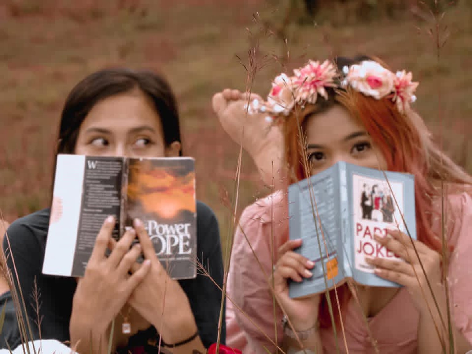 Two women holding books outdoors