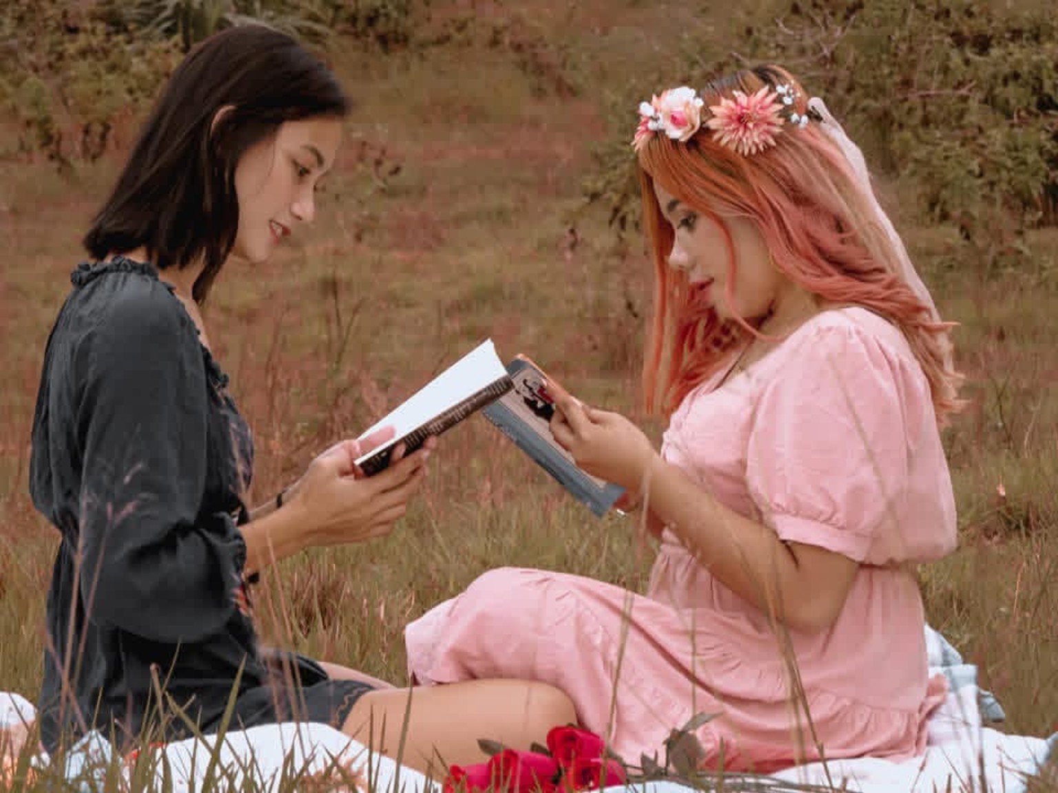Two women sharing a quiet reading moment outdoors