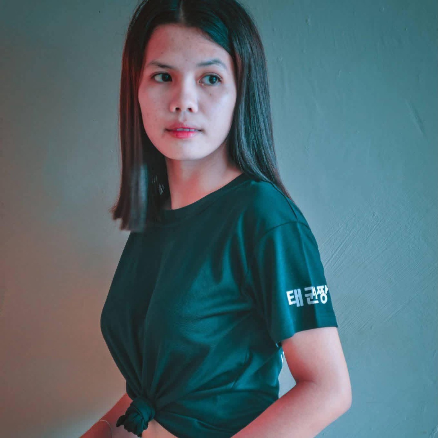 Woman in a green shirt in soft indoor light