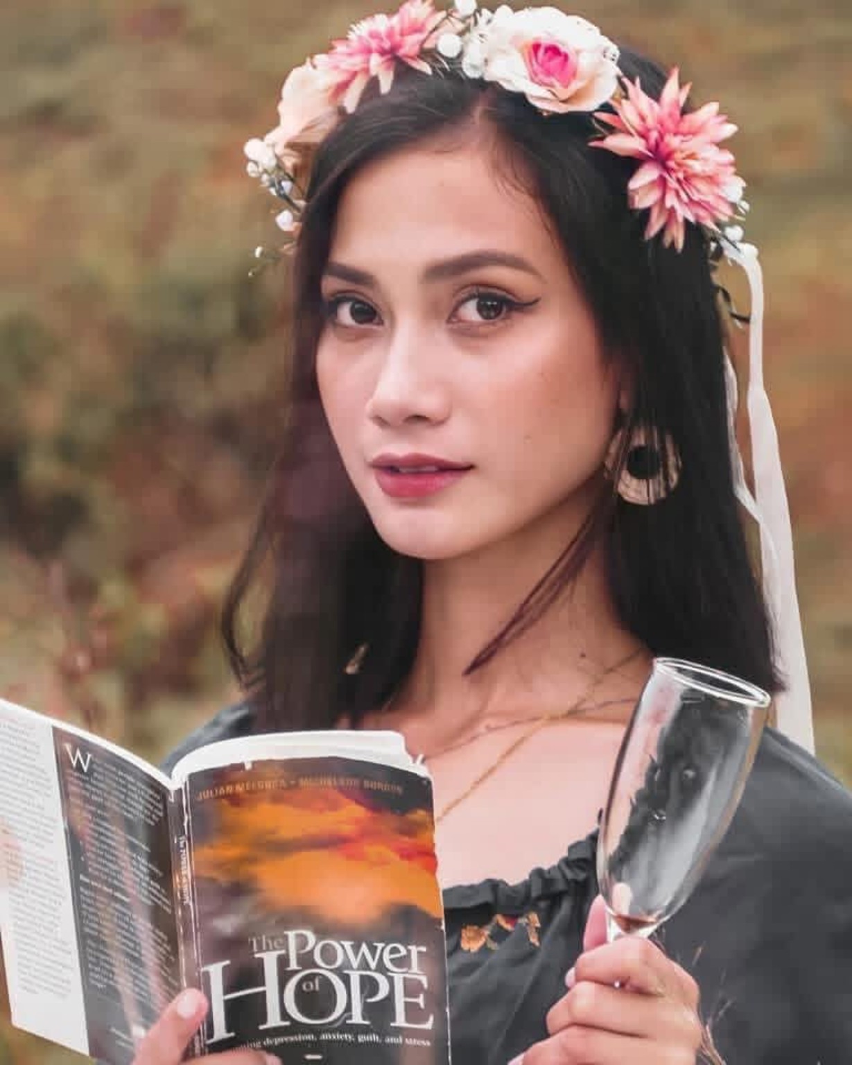 Woman with a flower crown holding a book